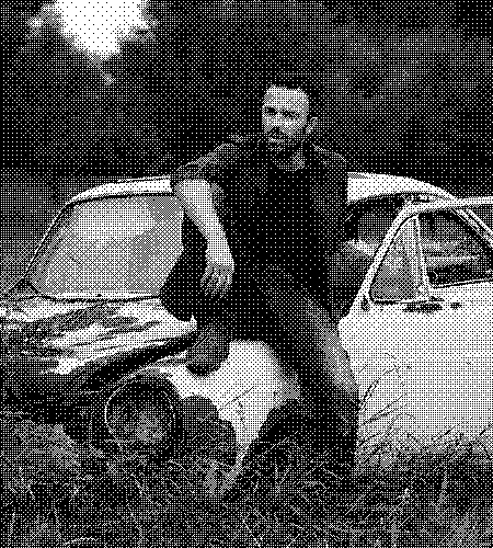 image of a younger man sitting on a car